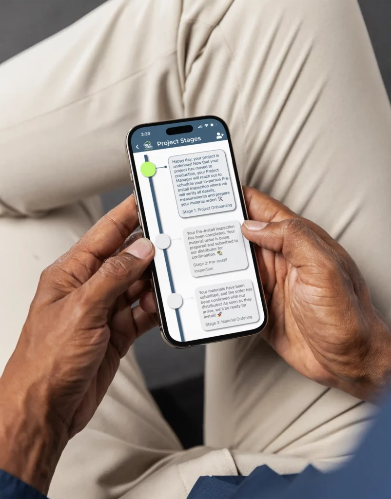 Photo of a person holding their phone with the NexGen Home Pro App showing the project tracking screen with the latest updates.