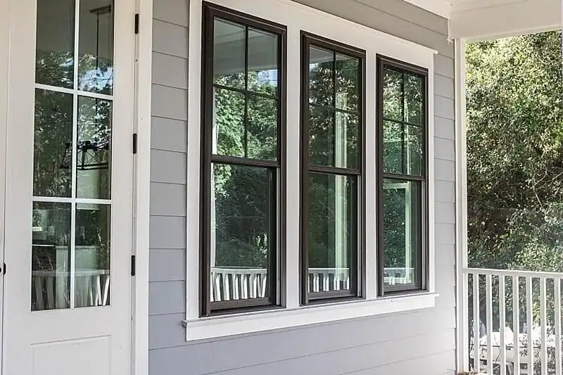 Photo of white trim around a dark brown casing enclosing three Viwinco windows.