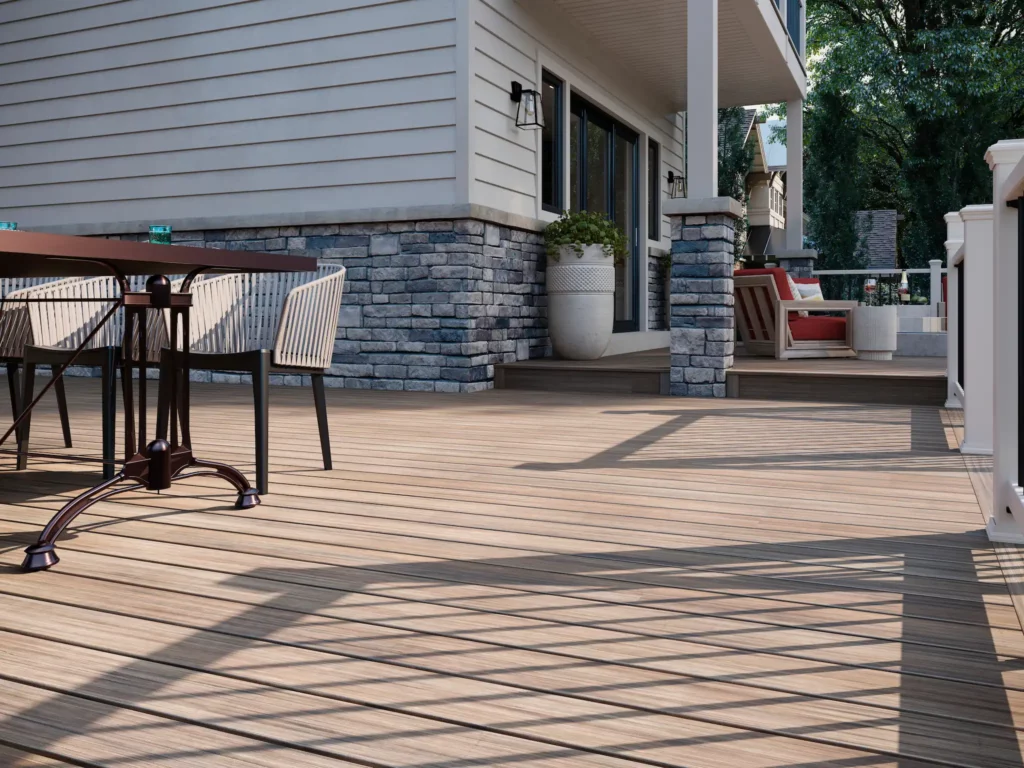 Photo of a modern deck with lounge chairs and dark metal table.