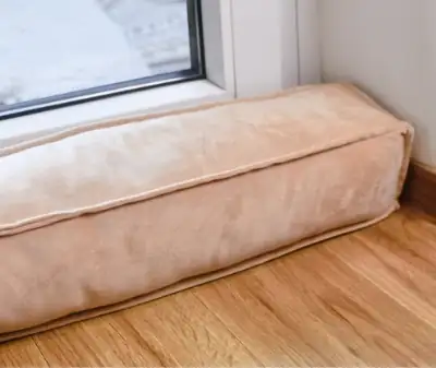 Photo of a door with a pillow in along the baseboard to block drafts.
