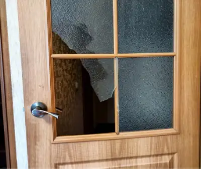 Photo of an old, weathered door with broken window.