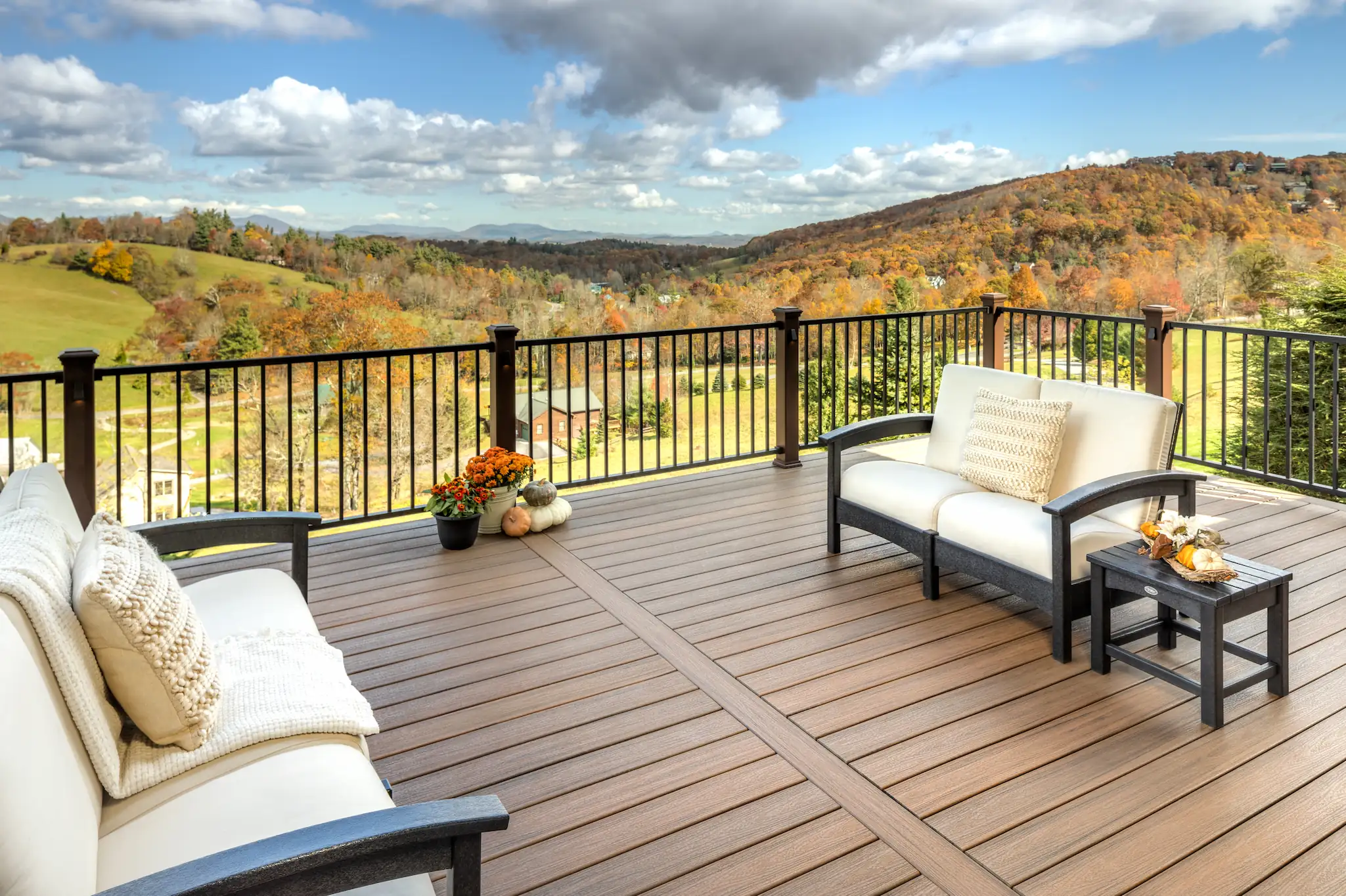 Photo from a modern-furnished Trex deck overlooking a beautiful vista of colorful trees in Fall across rolling hills.