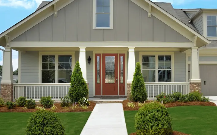 Photo of the front of a house with stained glass accented door representing the styles available from ThermaTru.