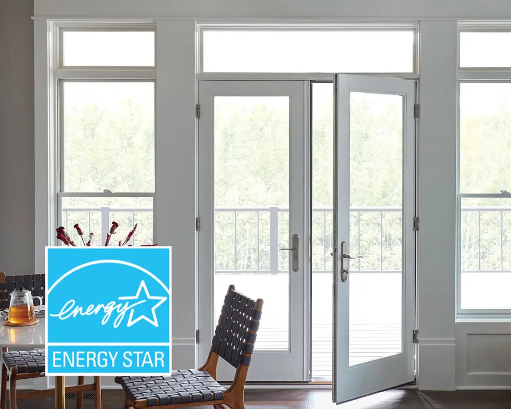 Photo looking out through a double-glass door with white trim and windows above, below, and on either side. The windows are Energy Star certified from Pella.