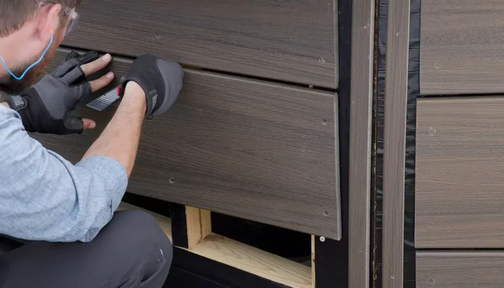 Team member installing simulated wood siding.
