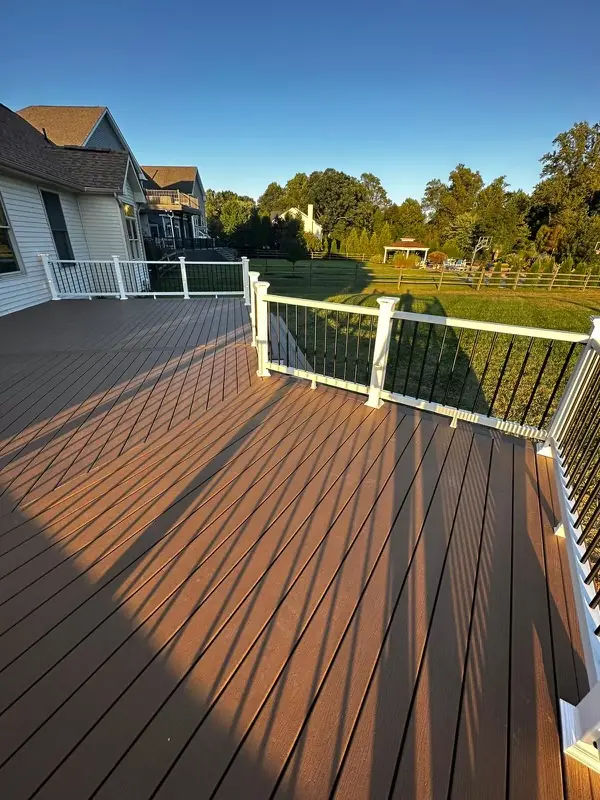 Photo of visually striking Trex deck overlooking a large yard with wooden fence.
