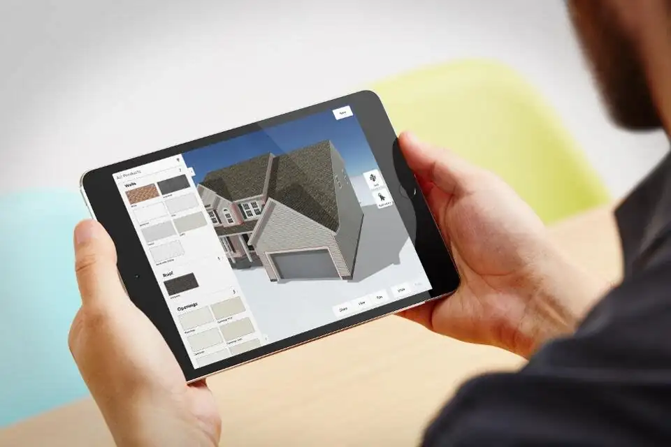 Photo of a person looking at a tablet device collaborating over a home design.