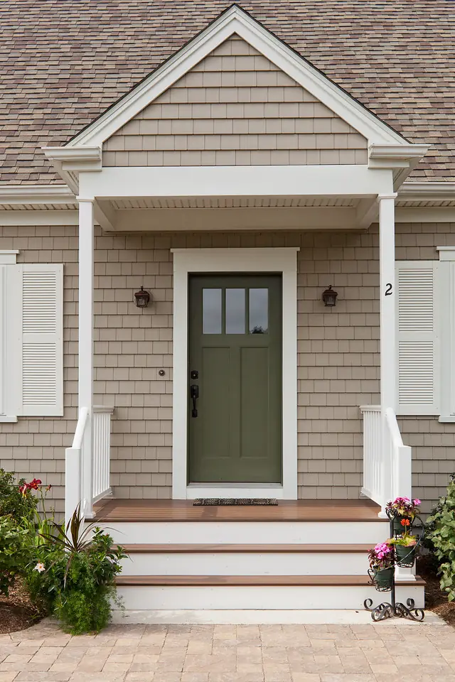 Photo of the front porch of a home with a green door and beige/tan low-maintenance siding protected by a CertainTeed warranty.