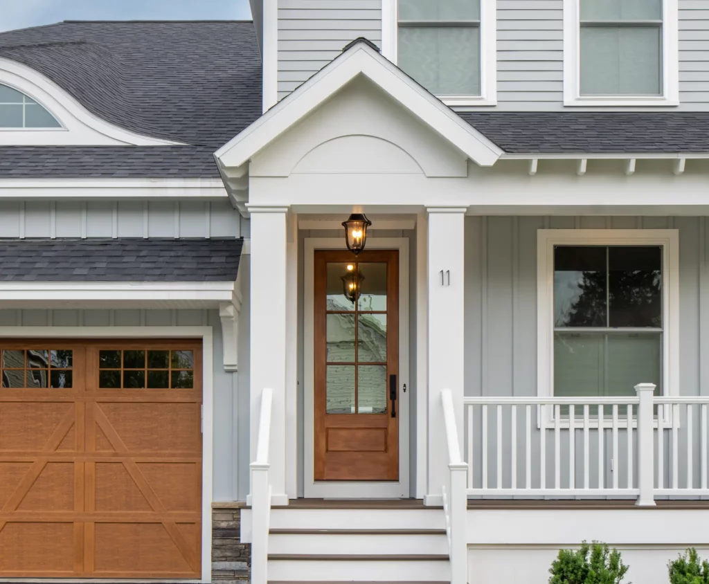 Photo of the front of a home with gray vertical and horizontal James Hardie siding and wood front and garage doors providing unmatched curb appeal.