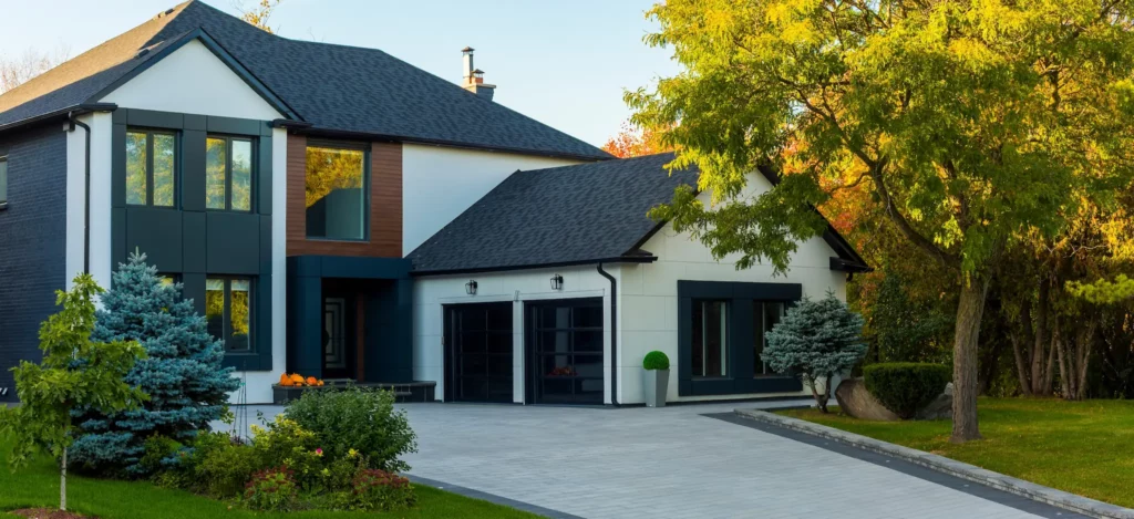 Photo of home with a mix of red brick, white stucco, and wood siding and modernist black trim and entrance way.