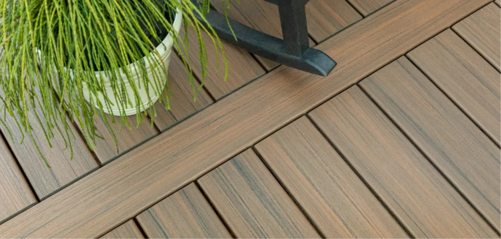 Trex decking close-up with a potted plant and the leg of a chair at the top.